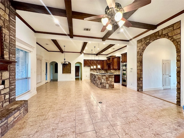 unfurnished living room featuring ceiling fan, crown molding, light tile patterned floors, and beam ceiling