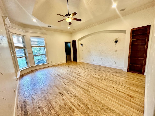 empty room with ornamental molding, ceiling fan, and light wood-type flooring