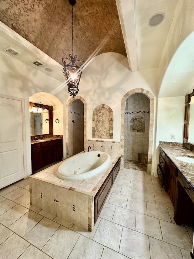 bathroom with vanity, independent shower and bath, and vaulted ceiling