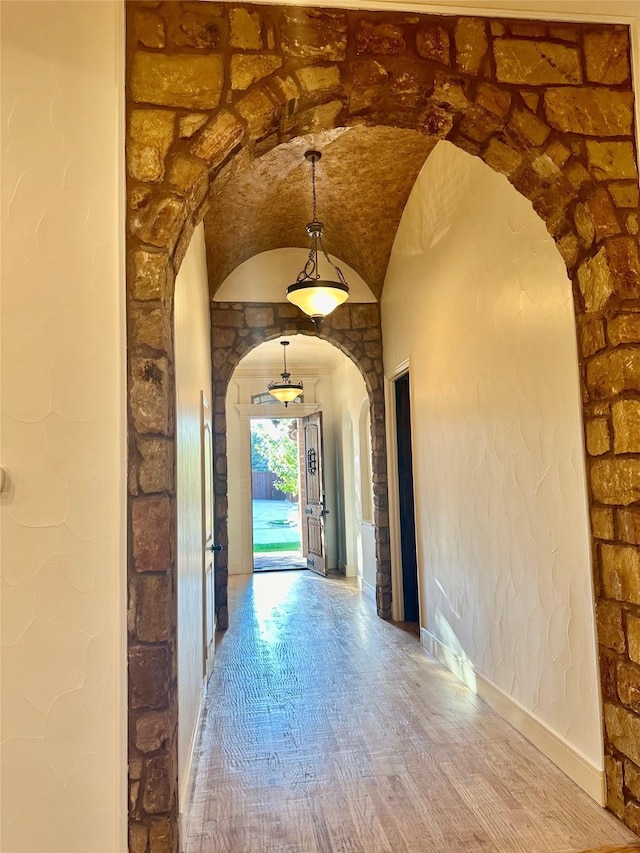 hallway with hardwood / wood-style flooring and lofted ceiling