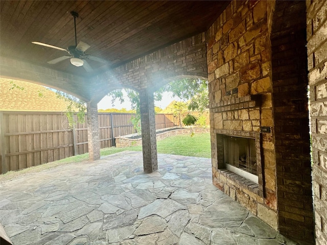 view of patio / terrace with ceiling fan and an outdoor stone fireplace