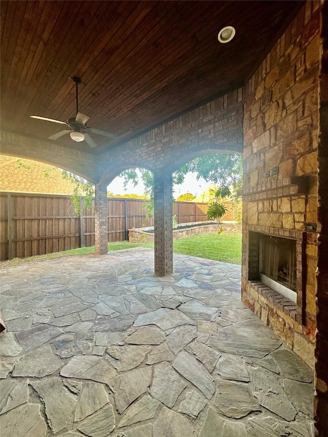 view of patio / terrace with ceiling fan and an outdoor stone fireplace