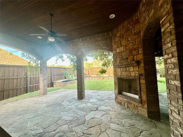 view of patio featuring ceiling fan and an outdoor stone fireplace