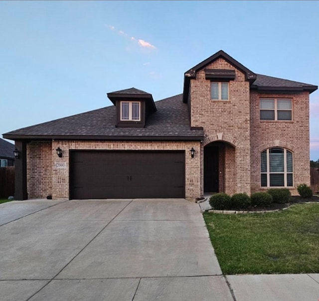 view of front of property with a garage and a yard