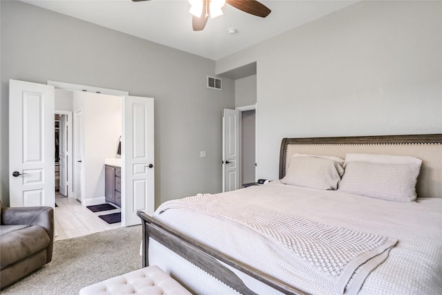 carpeted bedroom with connected bathroom and ceiling fan