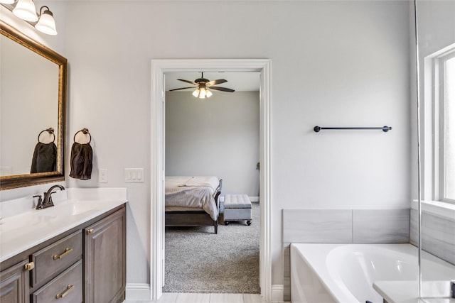 bathroom with ceiling fan, vanity, and a bathing tub