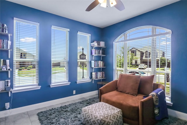 sitting room with tile patterned flooring and ceiling fan