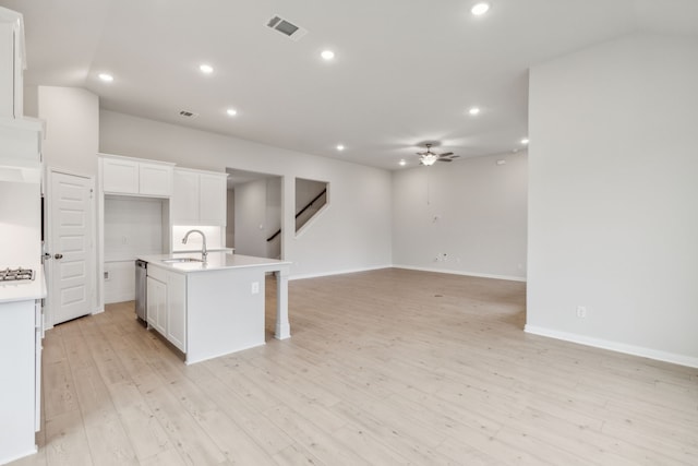 kitchen with sink, white cabinetry, a center island with sink, light wood-type flooring, and dishwasher