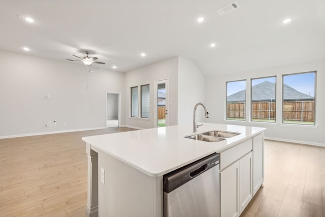 kitchen with an island with sink, sink, white cabinets, stainless steel dishwasher, and light wood-type flooring