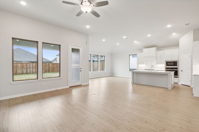 unfurnished living room with ceiling fan, plenty of natural light, and light hardwood / wood-style floors