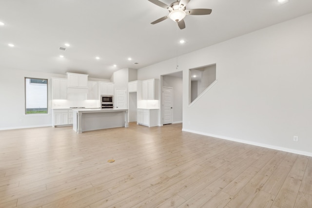 unfurnished living room with ceiling fan and light hardwood / wood-style floors