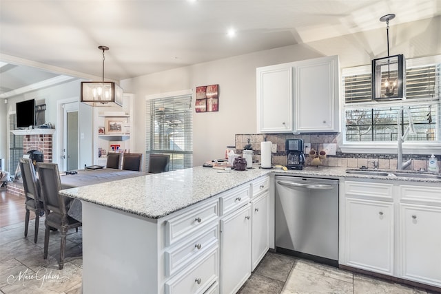 kitchen with decorative light fixtures, stainless steel dishwasher, white cabinets, and kitchen peninsula