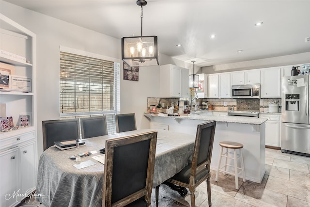 dining area featuring sink and a chandelier