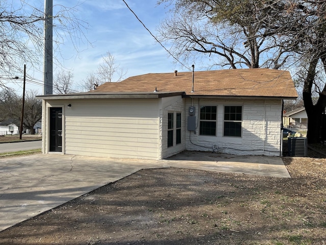 rear view of property with central AC unit and a patio