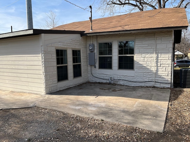 view of side of home featuring cooling unit and a patio