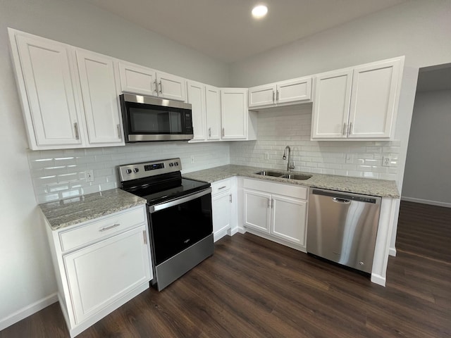 kitchen featuring stainless steel appliances, sink, white cabinets, and light stone counters