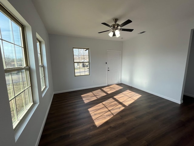 spare room with dark wood-type flooring and ceiling fan