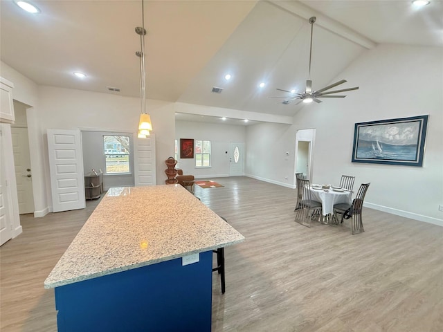 kitchen featuring ceiling fan, high vaulted ceiling, decorative light fixtures, beamed ceiling, and light wood-type flooring