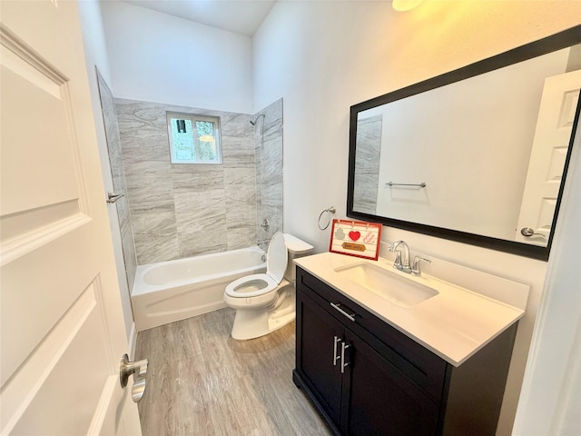 full bathroom with tiled shower / bath combo, vanity, hardwood / wood-style flooring, and toilet