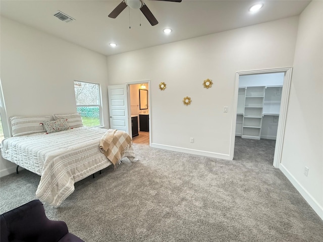 carpeted bedroom with a spacious closet, ceiling fan, and a closet