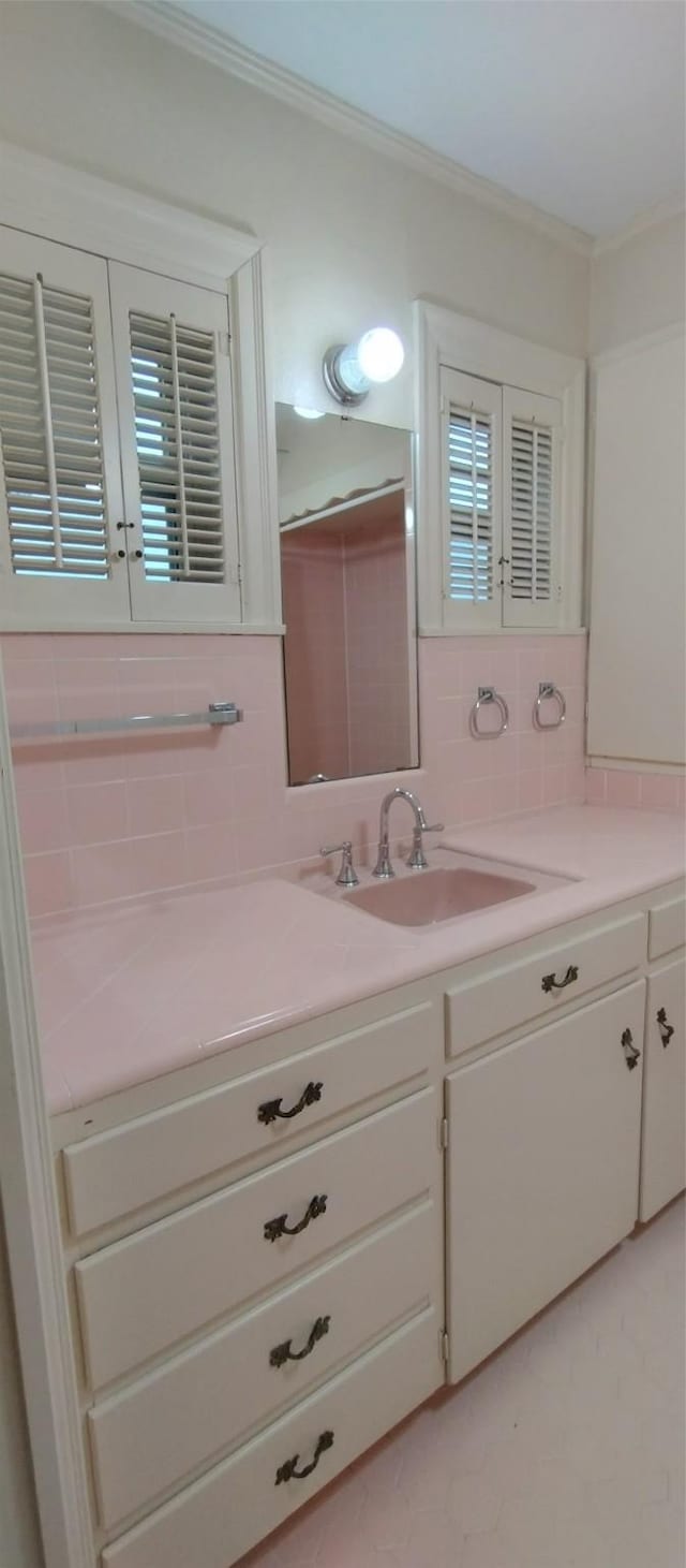 bathroom with ornamental molding, vanity, and backsplash