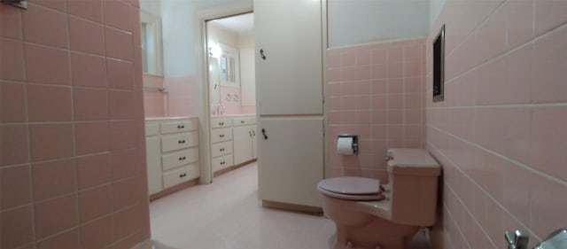 bathroom featuring tile walls and toilet