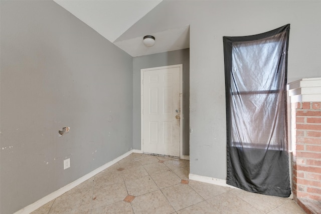 tiled empty room with vaulted ceiling