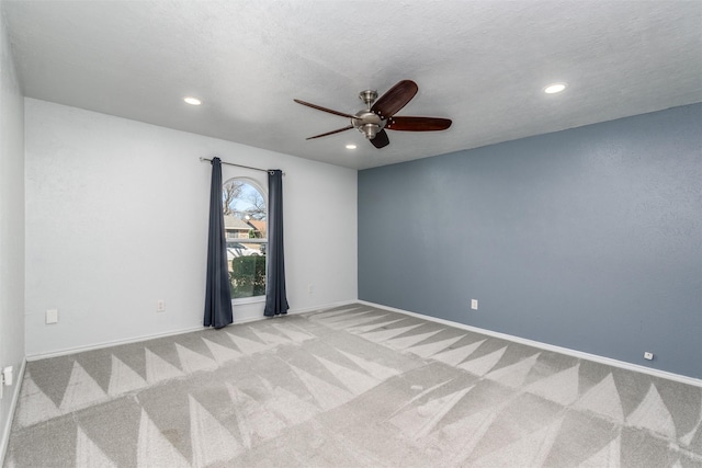 unfurnished room with light colored carpet, a textured ceiling, and ceiling fan