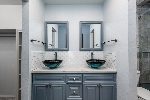 bathroom featuring tasteful backsplash, vanity, a shower, and toilet