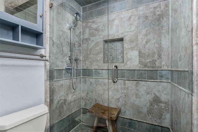 bathroom featuring toilet and a shower with door