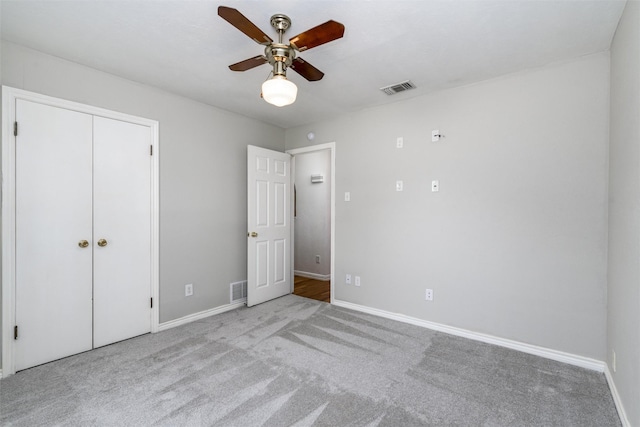 unfurnished bedroom with ceiling fan, a closet, and light carpet