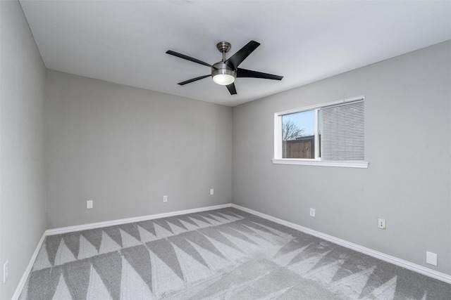 carpeted spare room featuring ceiling fan