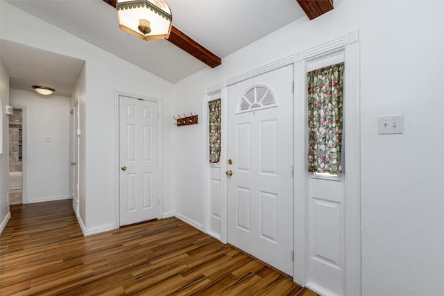 foyer with dark hardwood / wood-style flooring and lofted ceiling with beams