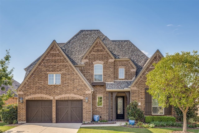 tudor-style house with a garage and a front lawn