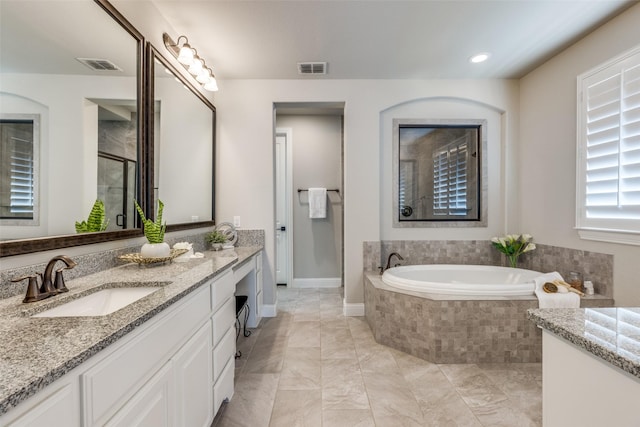 bathroom featuring vanity and independent shower and bath