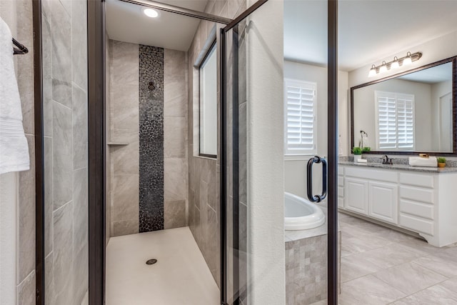 bathroom with vanity and shower with separate bathtub