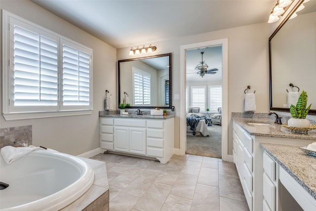 bathroom featuring vanity, tiled bath, and ceiling fan