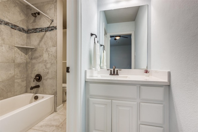 full bathroom featuring vanity, tile patterned flooring, tiled shower / bath combo, and toilet