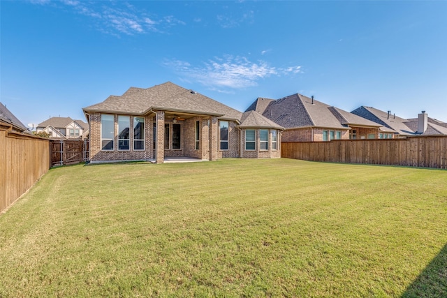 rear view of property with a lawn and a patio area