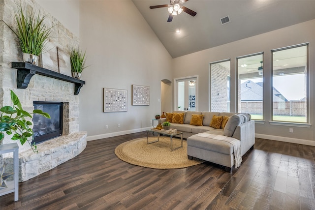 living room with dark hardwood / wood-style flooring, a fireplace, high vaulted ceiling, and ceiling fan