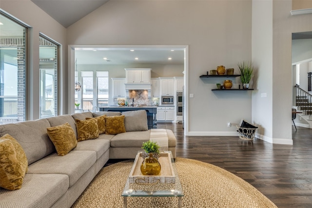 living room featuring lofted ceiling, sink, and dark hardwood / wood-style floors