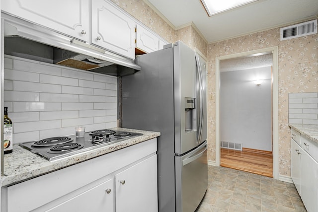 kitchen featuring tasteful backsplash, electric cooktop, light stone countertops, and white cabinets