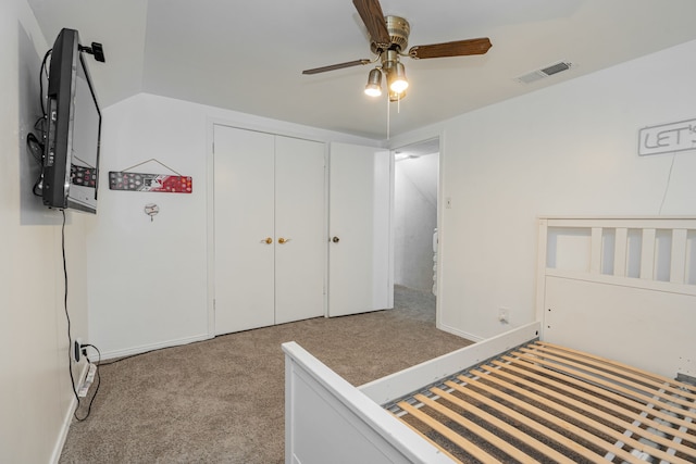 unfurnished bedroom with ceiling fan, light colored carpet, vaulted ceiling, and a closet