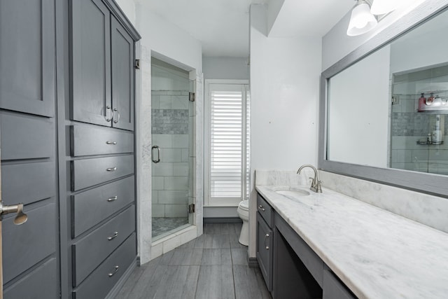 bathroom featuring walk in shower, vanity, and toilet