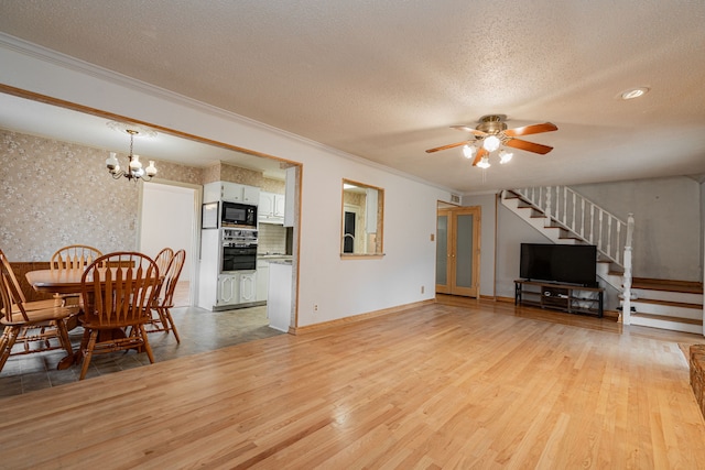 living room with crown molding, light hardwood / wood-style flooring, a textured ceiling, and ceiling fan with notable chandelier