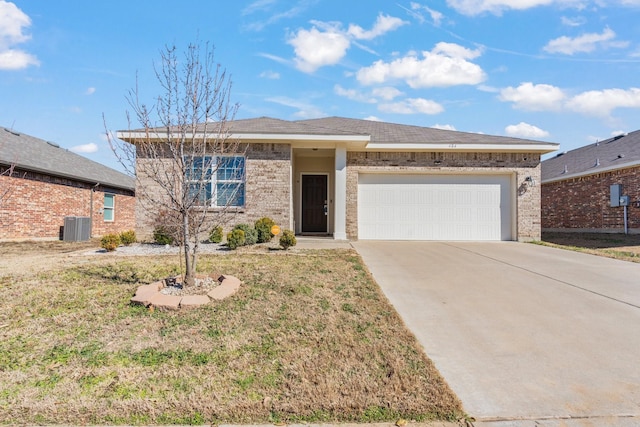 view of front of property with cooling unit, a garage, and a front yard