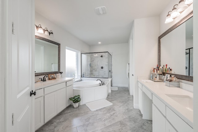 bathroom with vanity and shower with separate bathtub