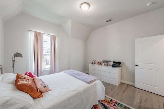 bedroom with lofted ceiling and light hardwood / wood-style flooring