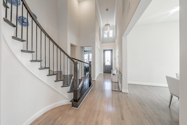 foyer entrance featuring a towering ceiling and hardwood / wood-style floors