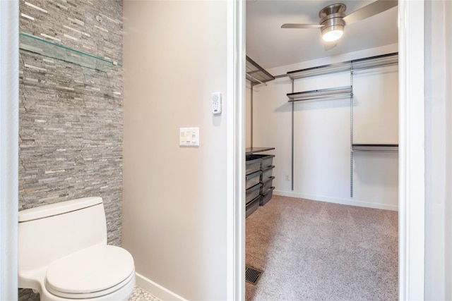 spacious closet with ceiling fan and light carpet